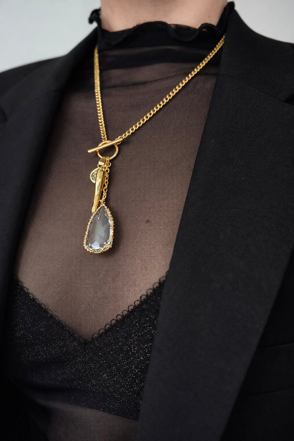 Γυναικείο κολιέ από ατσάλι σε χρυσό με αλυσίδα και ζιργκόν στοιχεία φορεμένο