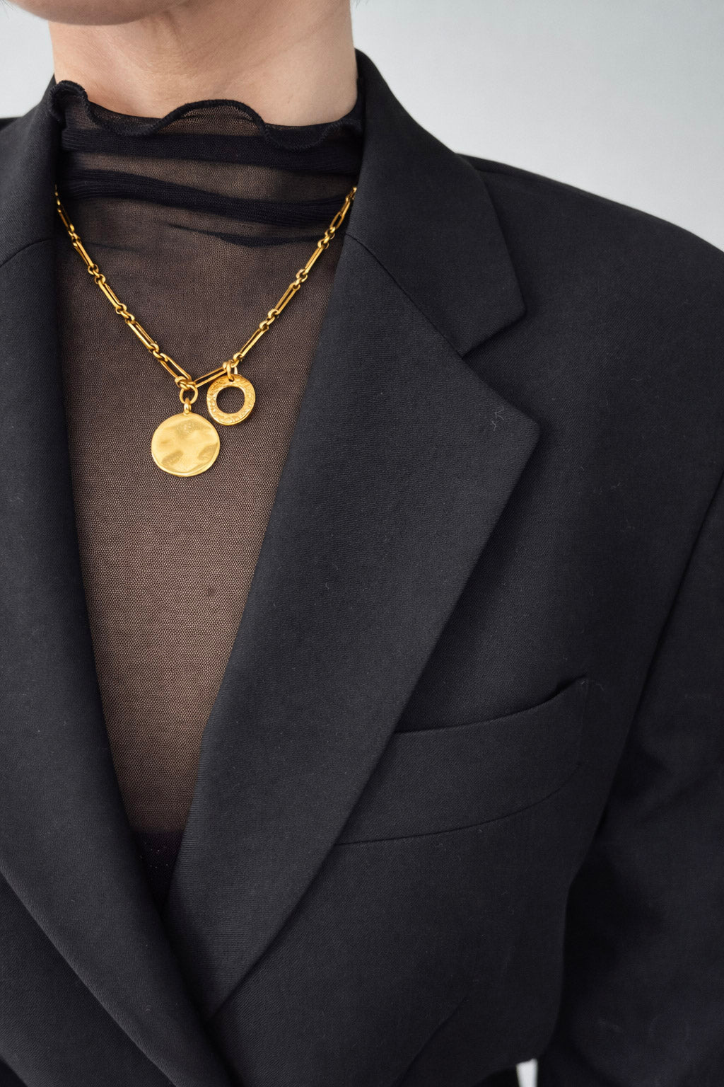 Γυναικείο κολιέ με αλυσίδα από ατσάλι σε χρυσό με στρογγυλό και κυκλικό στοιχείο on body