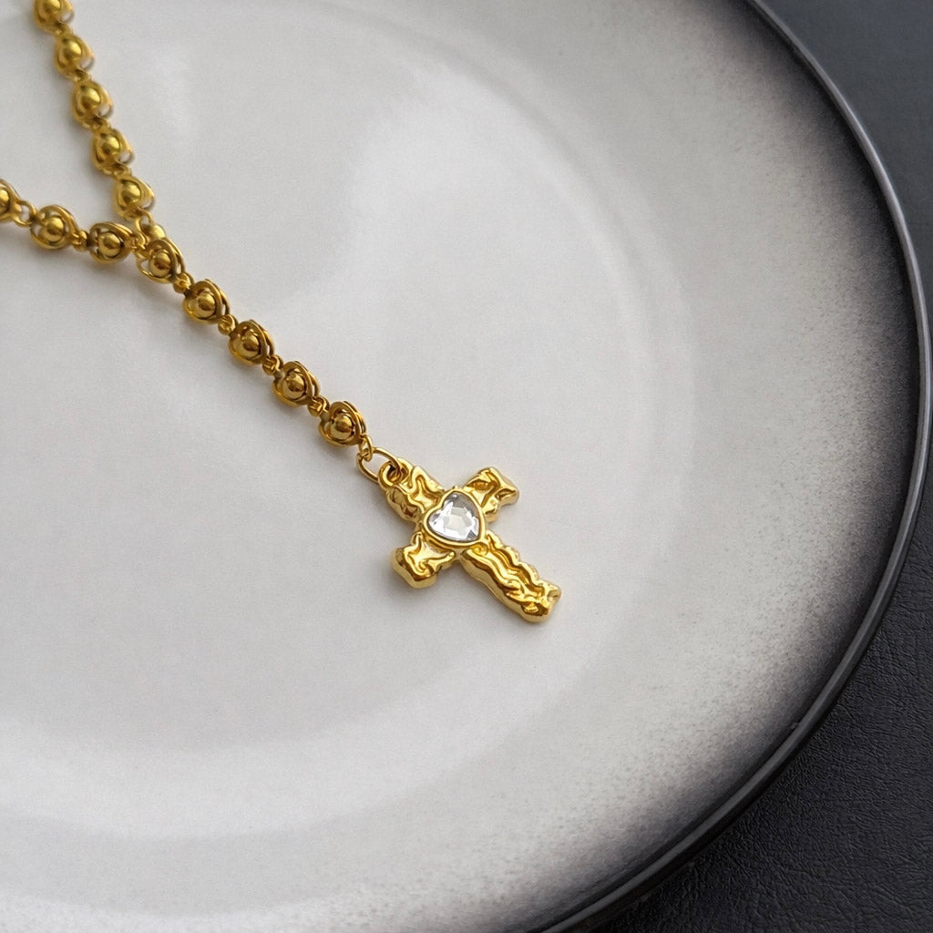 Γυναικείο κολιέ καρδιά από ατσάλι σε χρυσό χρώμα με σταυρό close up