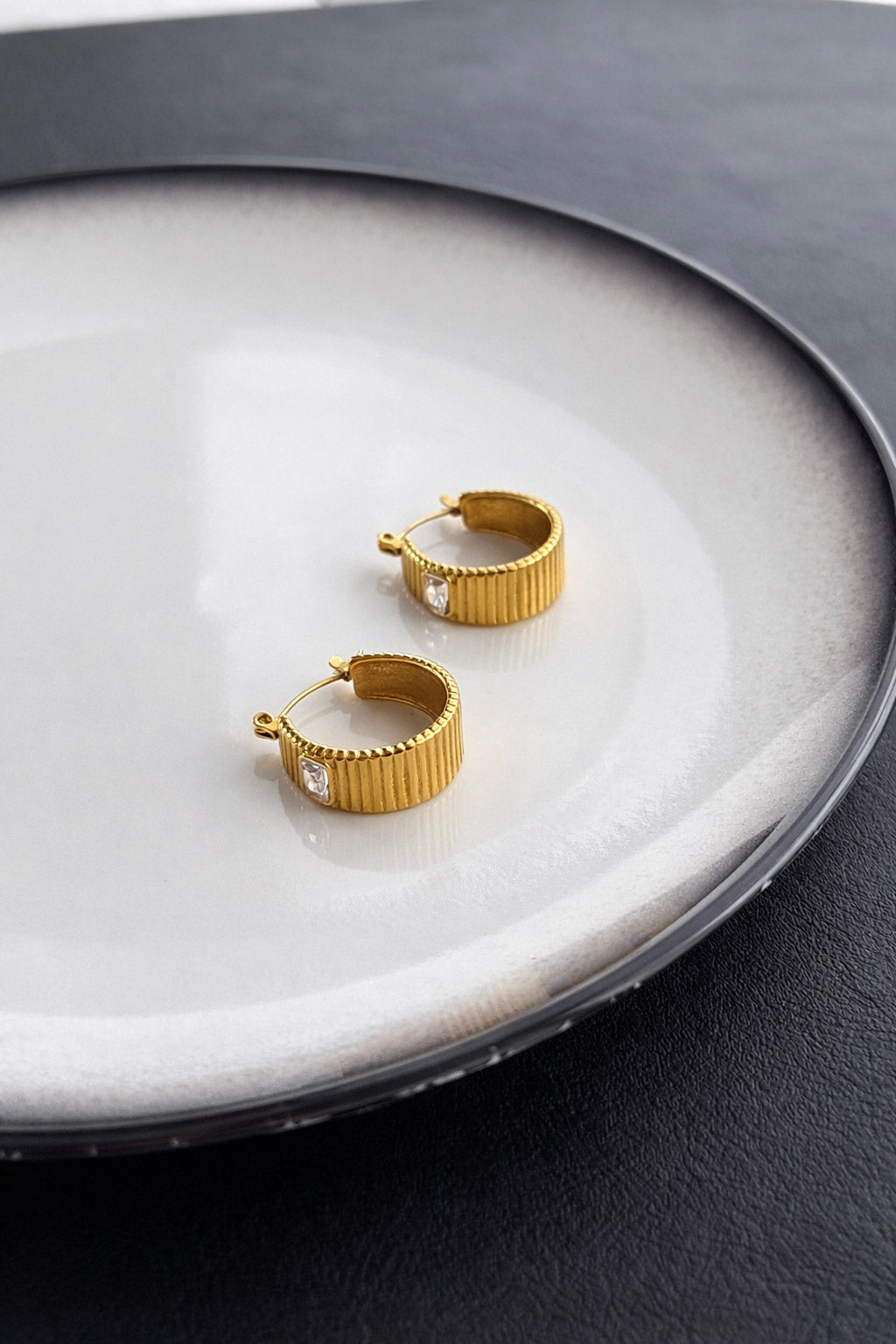 Γυναικεία σκουλαρίκια κρίκοι από ατσάλι σε χρυσό με ραβδωτή υφή και διάφανο ζιργκόν