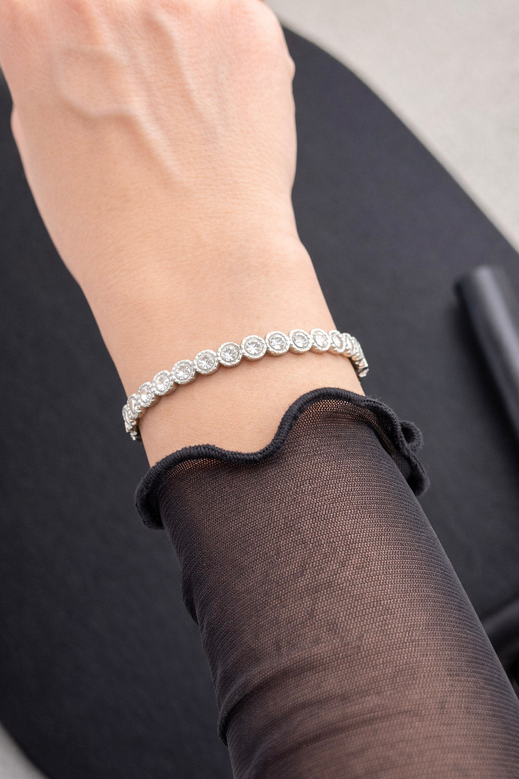 Γυναικείο statement βραχιόλι από ατσάλι σε ασημί με ζιργκόν φορεμένο