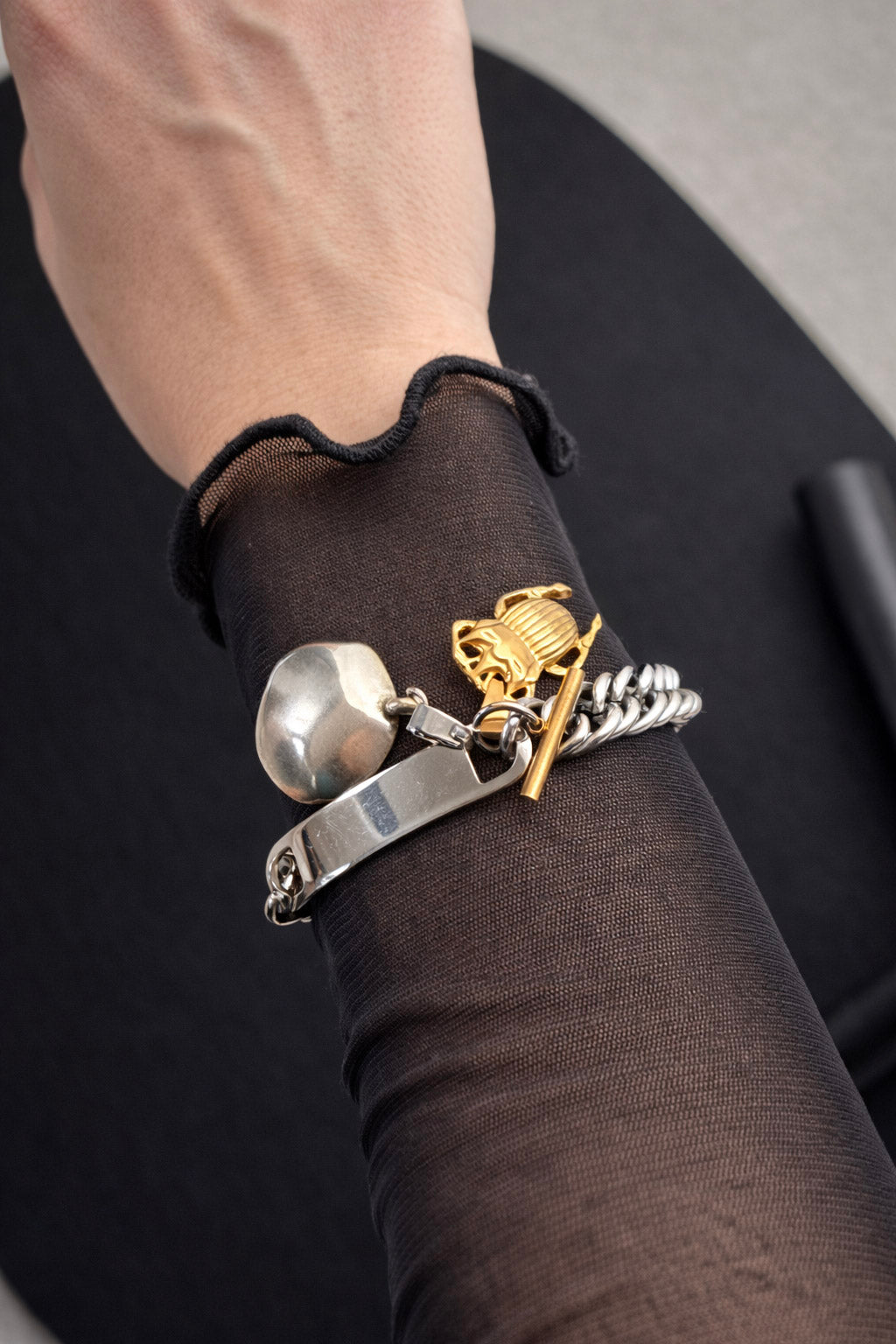 Γυναικείο statement βραχιόλι από ατσάλι σε ασημί χρώμα με χοντρή αλυσίδα και δίχρωμα στοιχεία φορεμένο