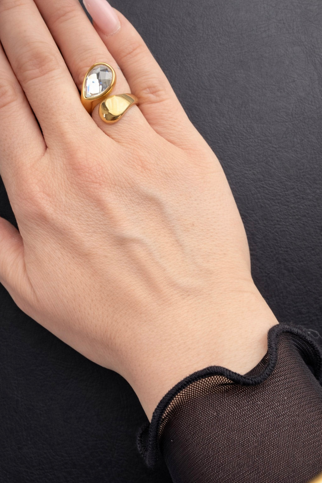 Γυναικείο δαχτυλίδι από ατσάλι σε χρυσό χρώμα με πέτρα ζιργκόν φορεμένο 