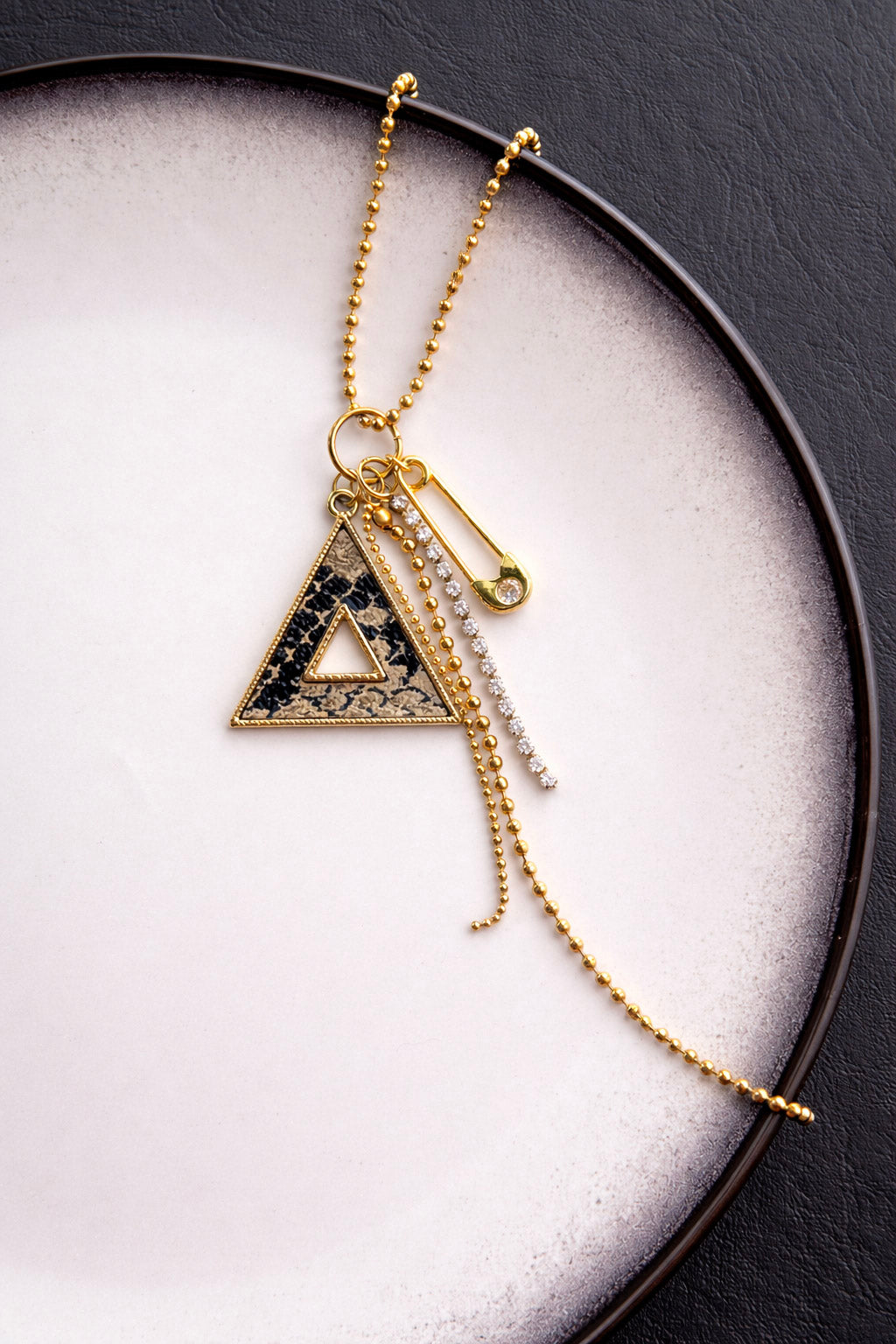 Γυναικείο κολιέ από ατσάλι σε χρυσό με γεωμετρικό τρίγωνο και αλυσίδες close up 