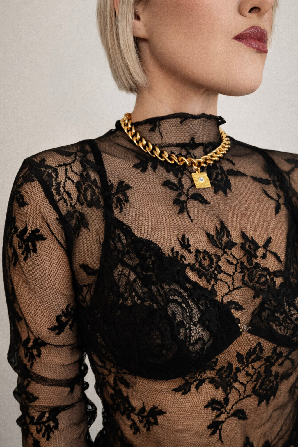 Γυναικείο κολιέ με χοντρή αλυσίδα από ατσάλι σε χρυσό με γεωμετρικό στοιχείο και ζιργκόν φορεμένο