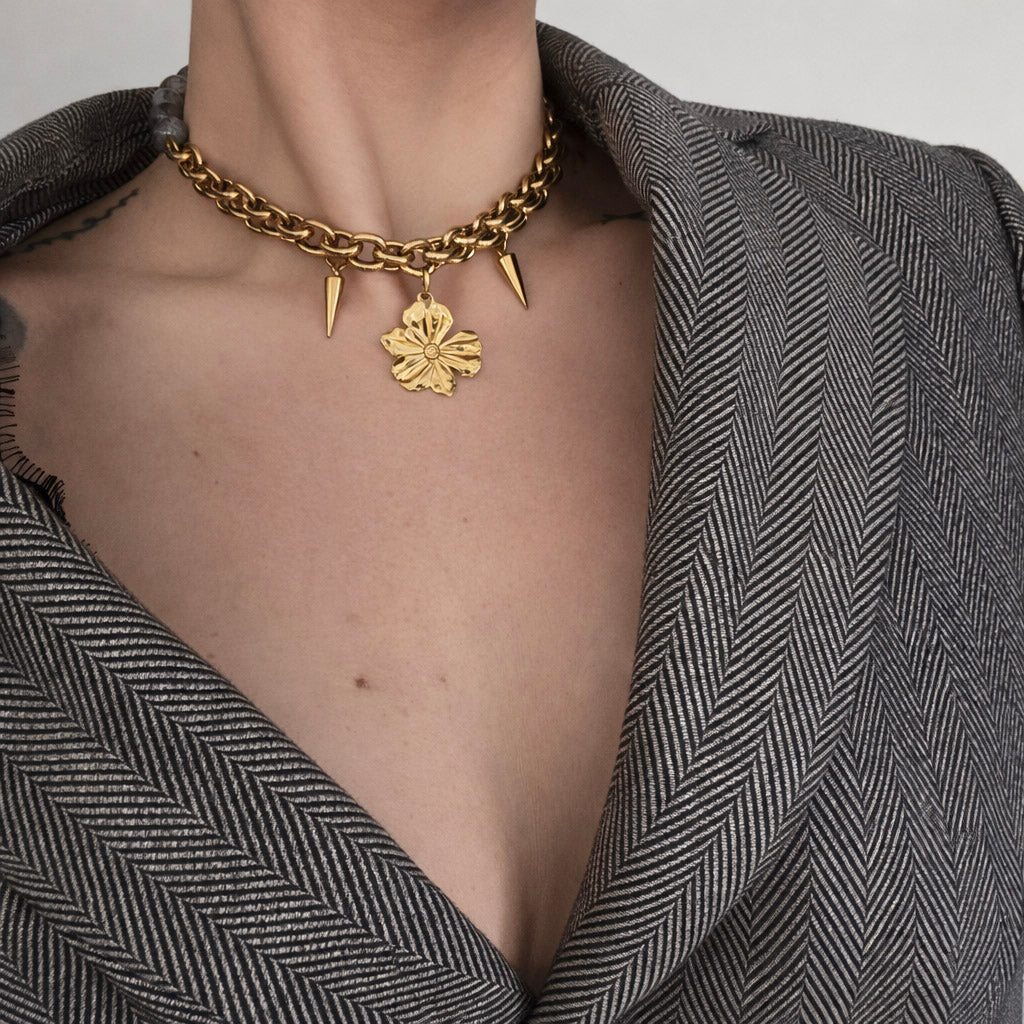 Γυναικείο κολιέ από ατσάλι σε χρυσό με χοντρή αλυσίδα και γκρι πέτρες φορεμένο