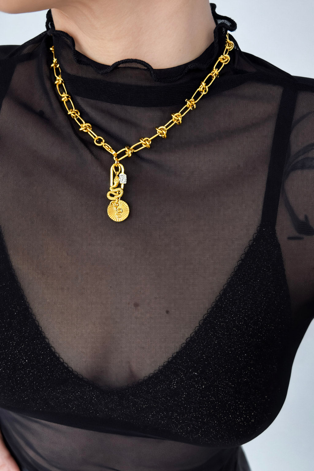 Γυναικείο κολιέ από ατσάλι σε χρυσό τόνο με αλυσίδα και στοιχεία φιδιού φορεμένο