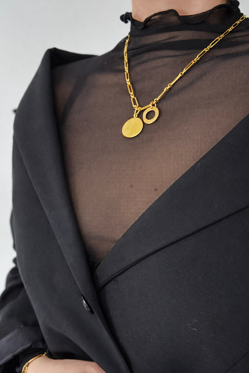 Γυναικείο κολιέ με αλυσίδα από ατσάλι σε χρυσό με στρογγυλό και κυκλικό στοιχείο φορεμένο
