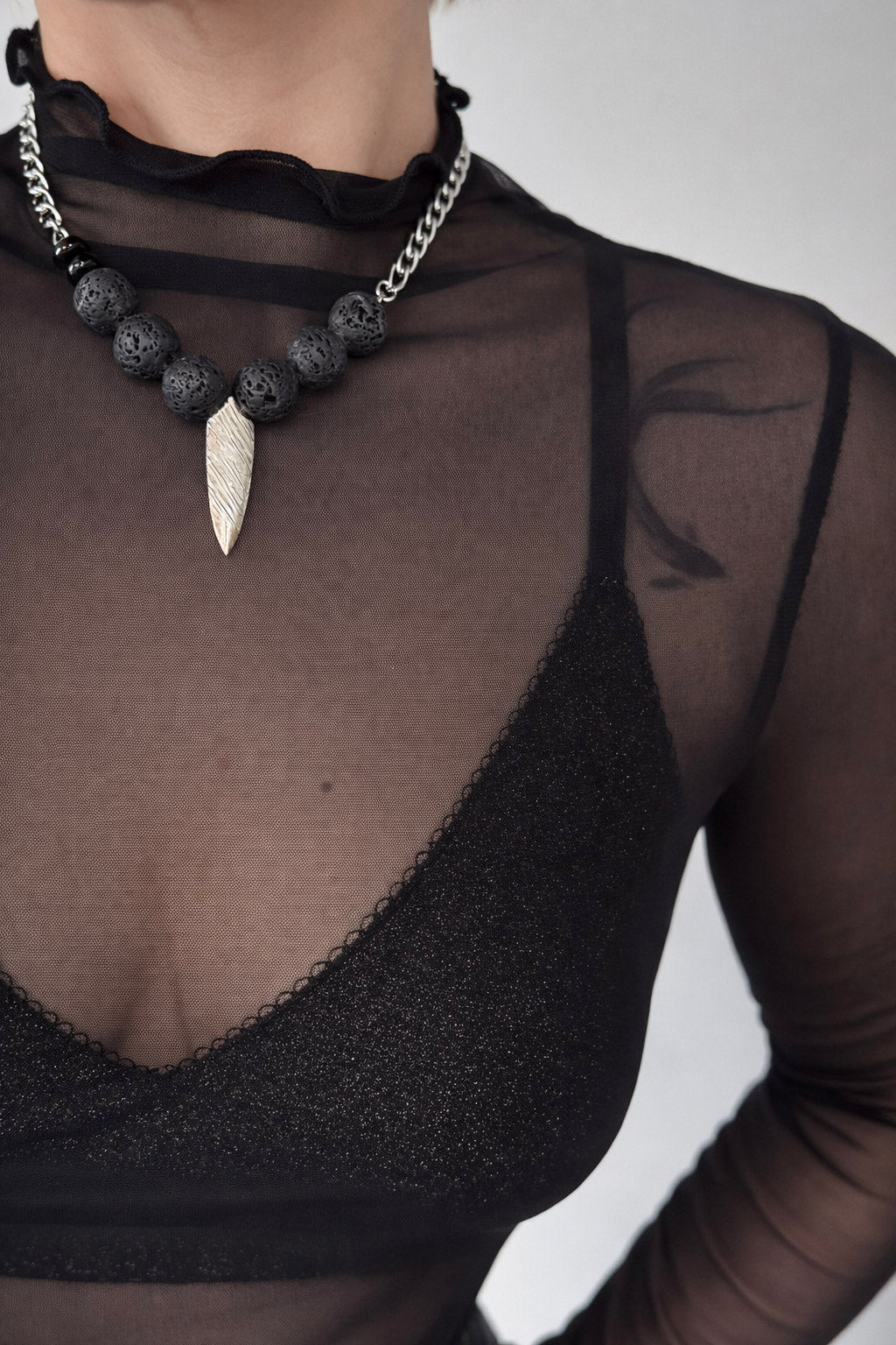 Γυναικείο κολιέ με πέτρες λάβας και ατσάλινο διακοσμητικό στοιχείο σε ασημί φορεμένο στον λαιμό
