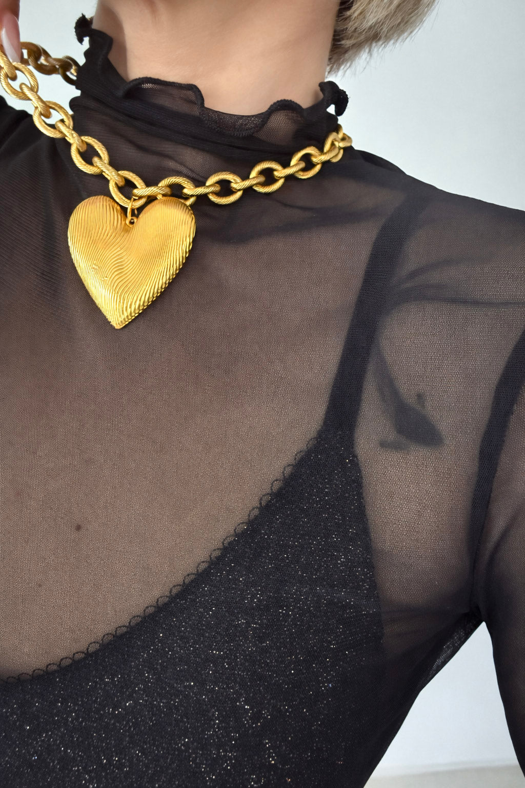 Χρυσό statement κολιέ από ατσάλι με έντονη αλυσίδα και μεγάλο ανάγλυφο charm καρδιάς on body