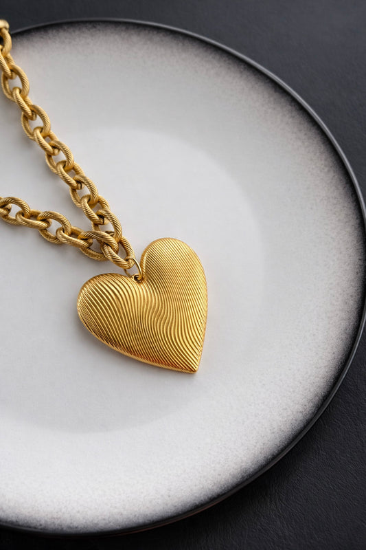 Χρυσό statement κολιέ από ατσάλι με έντονη αλυσίδα και μεγάλο ανάγλυφο charm καρδιάς