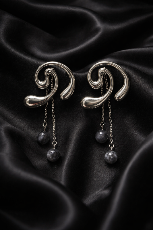 Σκουλαρίκια από ατσάλι ασημί με καμπύλες και κρεμαστά στοιχεία σε μαύρο φόντο