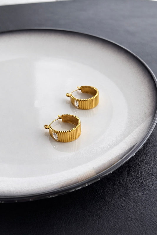 Γυναικεία σκουλαρίκια κρίκοι από ατσάλι σε χρυσό με ραβδωτή υφή και διάφανο ζιργκόν