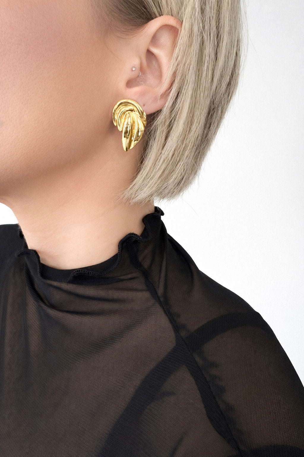 Γυναικεία σκουλαρίκια modern από ατσάλι σε χρυσό φορεμένα στο αυτί