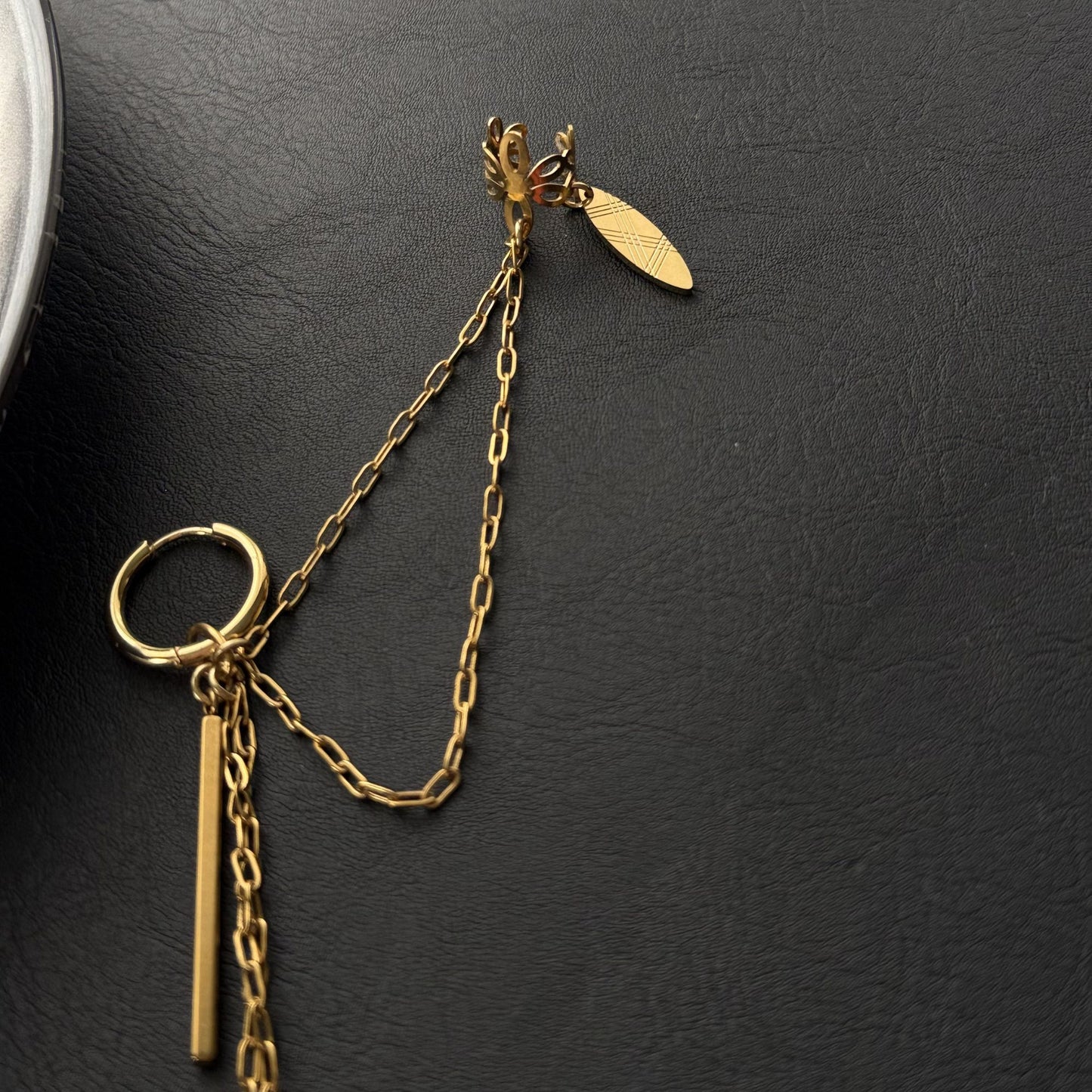 Σκουλαρίκι ear chain από ατσάλι σε χρυσό με αλυσίδες και κρεμαστά στοιχεία close up 