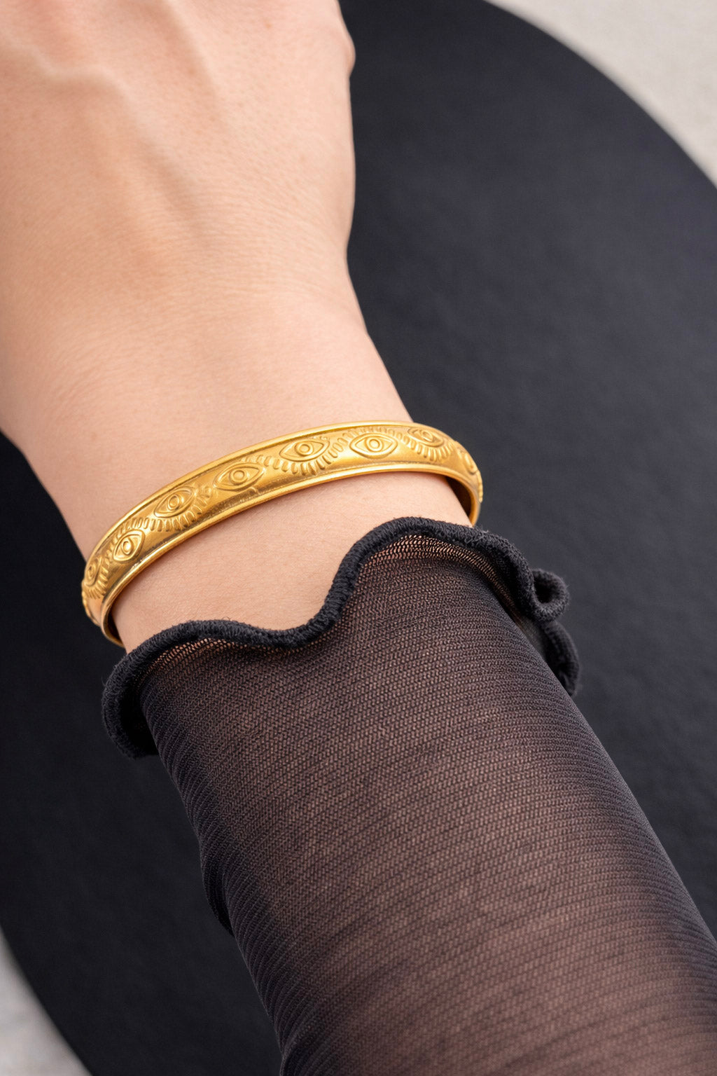 Γυναικείο χρυσό βραχιόλι cuff από ατσάλι με χαραγμένο μοτίβο ματιού φορμένο