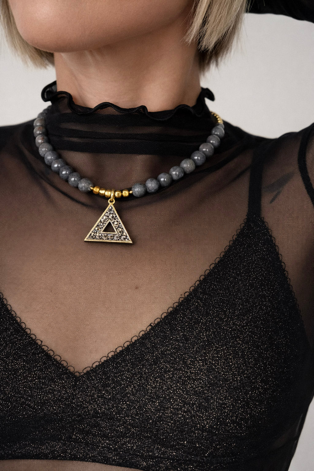 Γυναικείο statement κολιέ με γκρι πέτρες και χρυσό γεωμετρικό τριγωνικό στοιχείο από ατσάλι styling