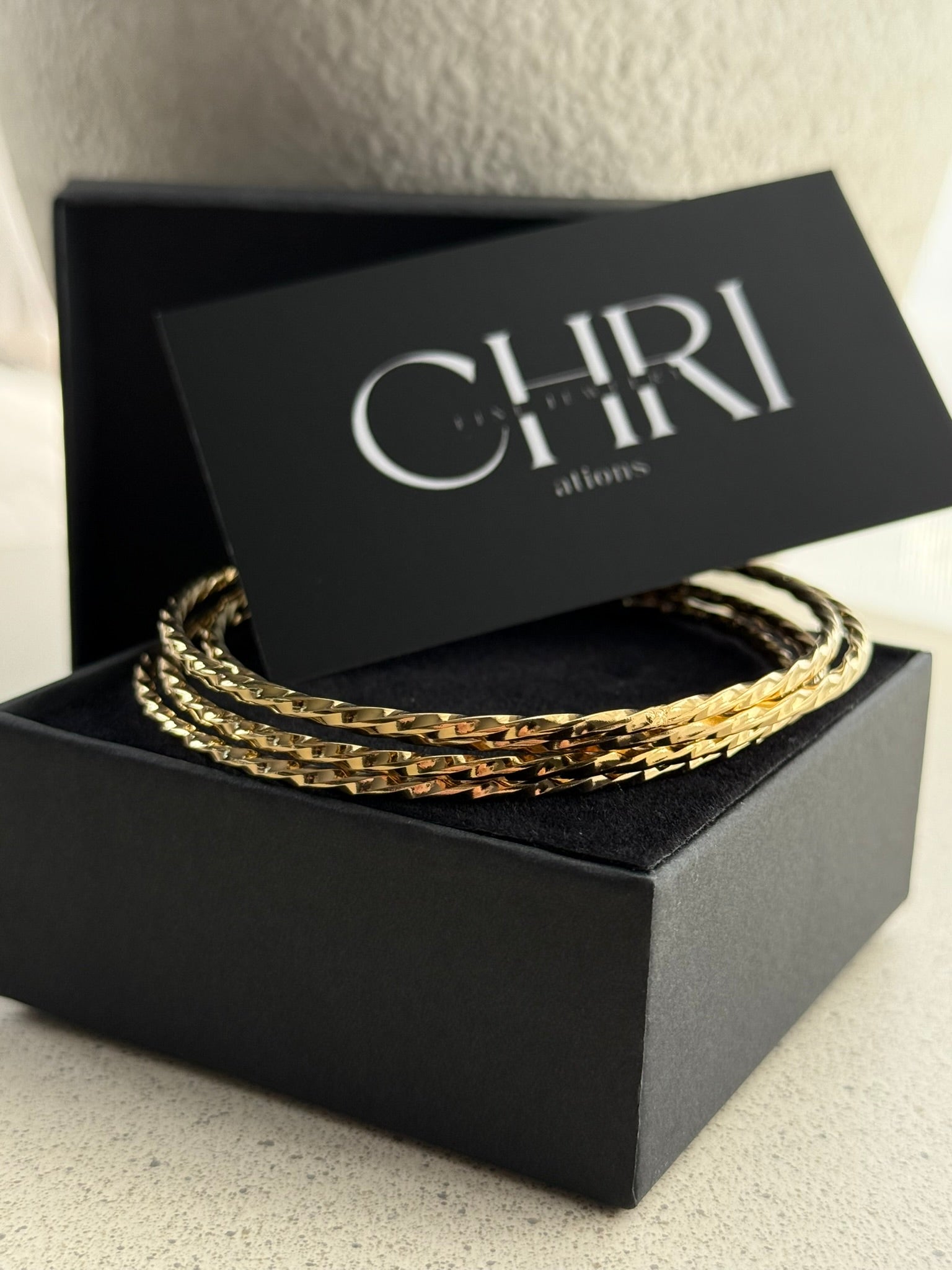 Γυναικείο σετ τεσσάρων βραχιολιών από ατσάλι σε χρυσό χρώμα με λεπτό ανάγλυφο σχέδιο